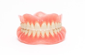 Complete set of dentures against white background