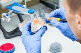 Dental lab technician working with wax model