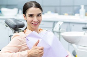 Happy dental patient making thumbs-up gesture