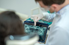 Dentist showing X-ray to patient