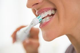 Close-up of woman’s mouth as she brushes her teeth