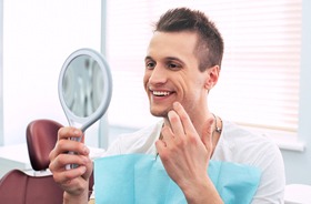 Man admiring his new smile after undergoing cosmetic treatment