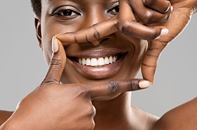Woman using her fingers to frame her bright, beautiful smile