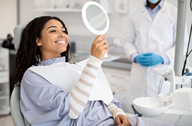 Dental patient admiring her teeth in the mirror